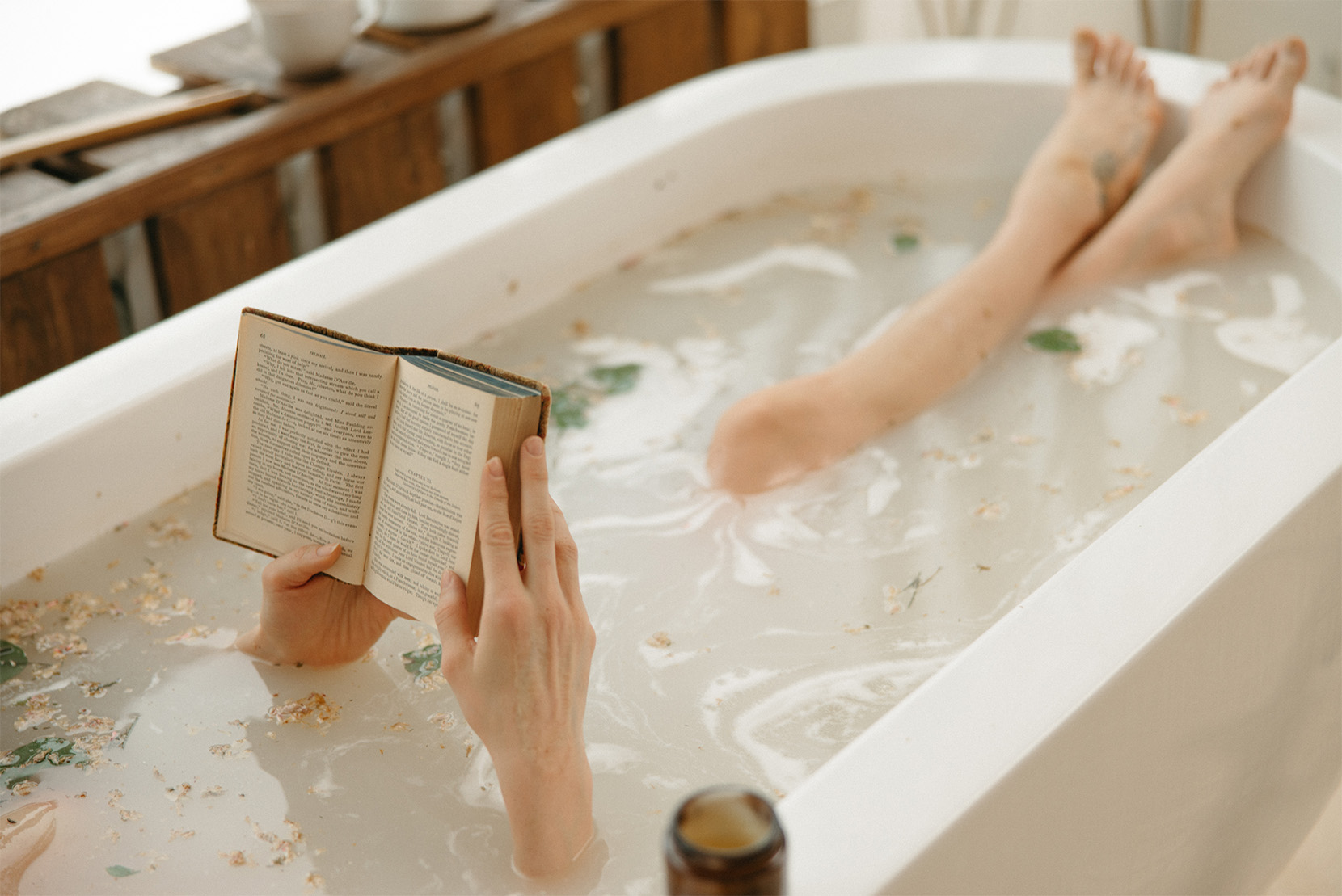 žena-leží-ve-vaně-a-relaxuje-s-knihou